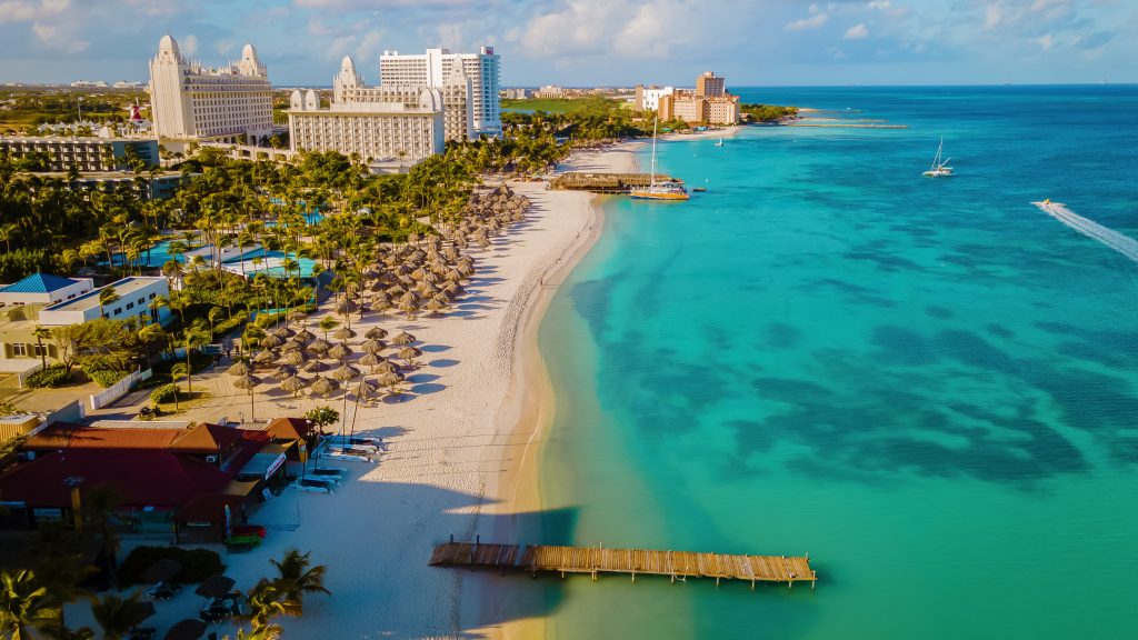 Palm beach Aruba Caribbean, white long sandy beach with palm trees at Aruba