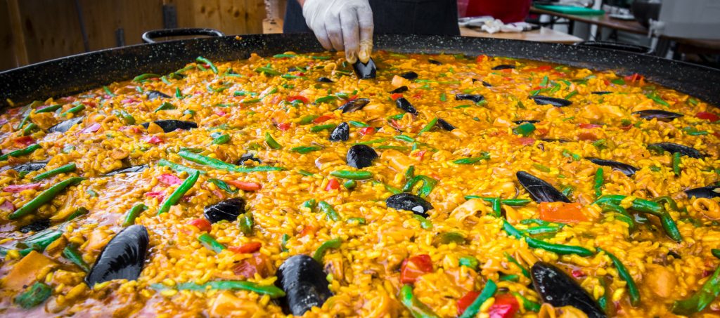 Chef cooking seafood paella on a street food festival, Spain - A Way To Go Travel