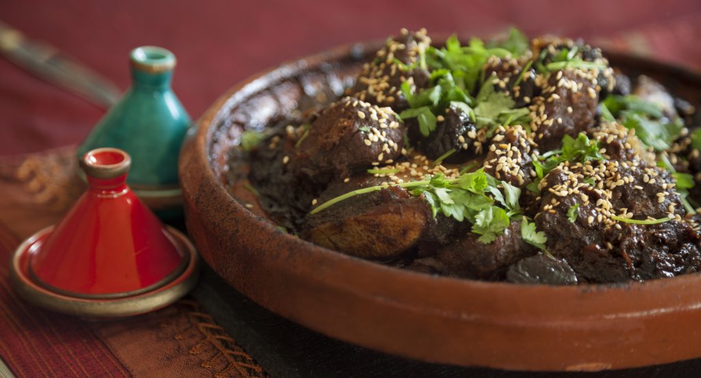 Meat and prune tagine garnished with fresh coriander and sesame seeds - A Way To Go Travel