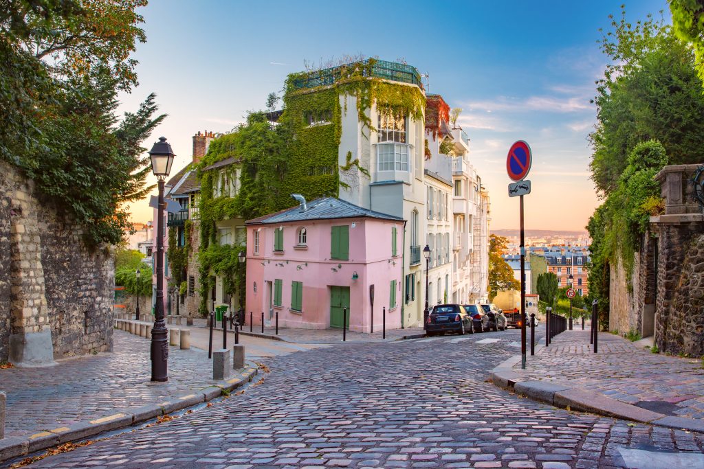 Cozy old street with pink house at the sunny sunrise, quarter Montmartre in Paris, France - A Way To Go Travel