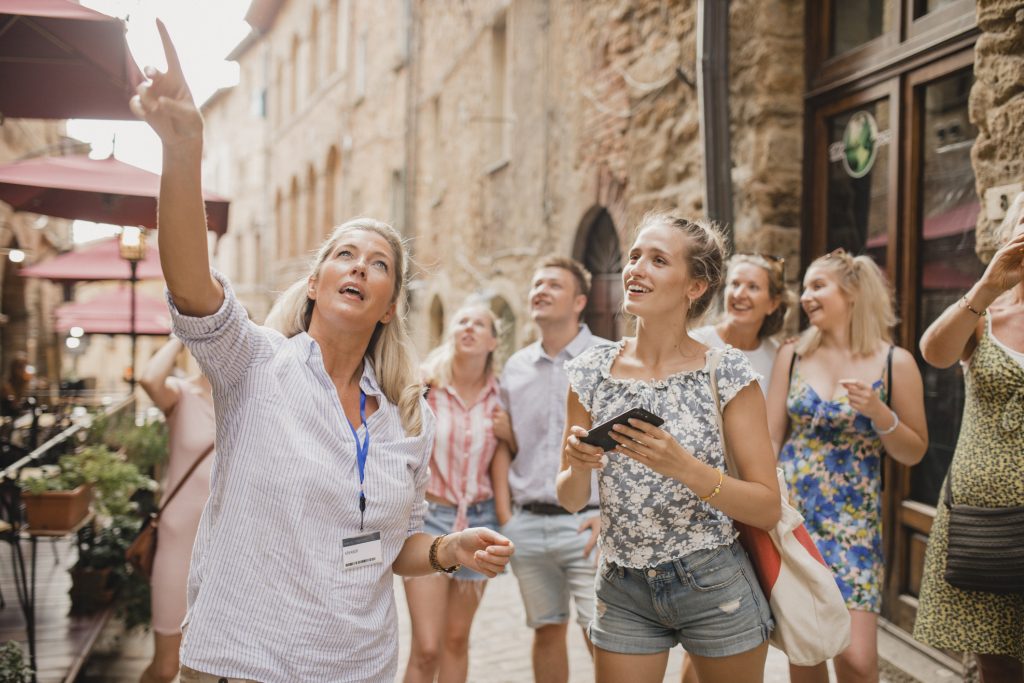 Group of people having a guided tour in the historic streets of Volterra - A Way To Go Travel