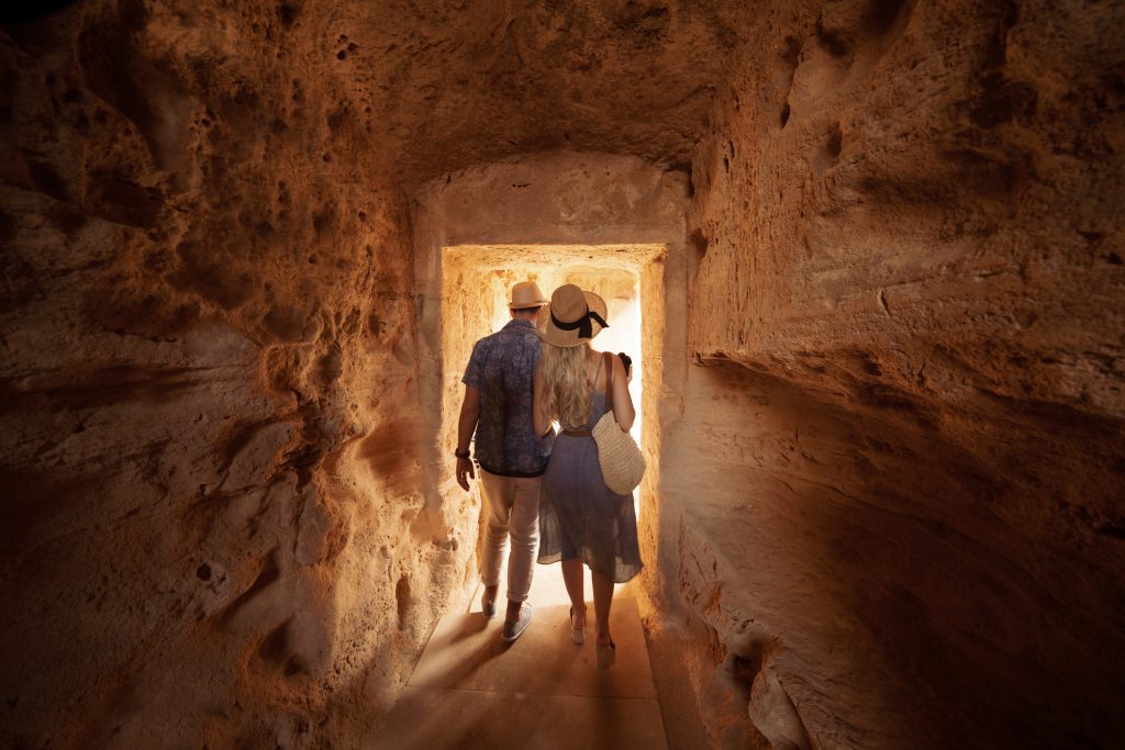 Tourists walking in tunnel and doing sightseeing at ancient archaeological tombs site in Italy - A Way To Go Travel